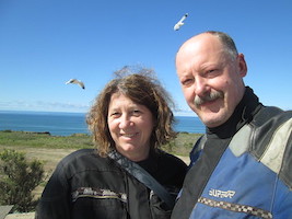 woman & man smiling with a blue sky behind them