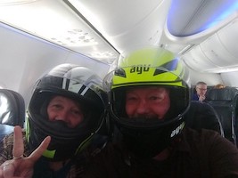 two people on a plane wearing motorcycle helmets